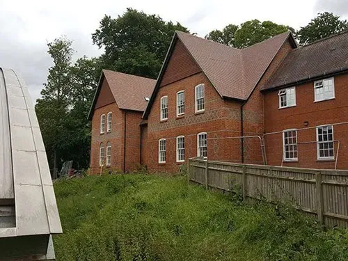A row of red brick houses next to a bridge.
