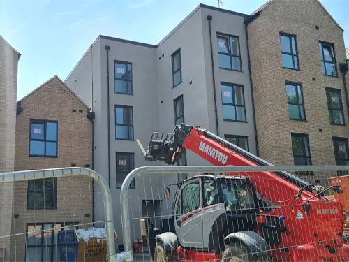 A crane is parked in front of a building.